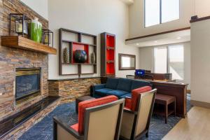 a living room with a couch and a fireplace at Comfort Suites Ogden Conference Center in Ogden