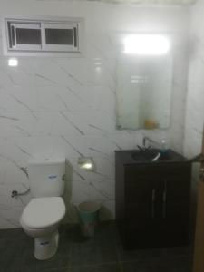ein Badezimmer mit einem weißen WC und einem Waschbecken in der Unterkunft R&r in Skhirat