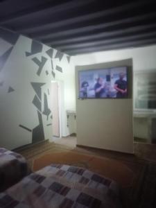 Zimmer mit einem TV an der Wand und einem Bett in der Unterkunft R&r in Skhirat
