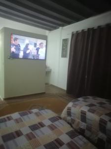 ein Schlafzimmer mit einem Bett und einem TV an der Wand in der Unterkunft R&r in Skhirat