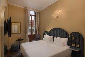 a bedroom with a large white bed and a window at NH Venezia Santa Lucia in Venice