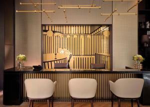 un salone con sedie bianche e specchio di art'otel Zagreb, Powered by Radisson Hotels a Zagabria