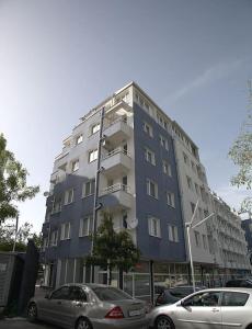 een hoog gebouw met auto's geparkeerd voor het bij Magenta Apartment with free WiFi in Sofia