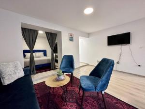 a living room with a couch and chairs and a tv at Apartment EASY HOME in Sarajevo