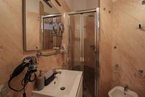een badkamer met een douche, een wastafel en een spiegel bij [Termini Treasure] - Elegant retreat in Rome
