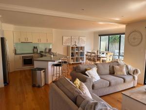 a living room with two couches and a kitchen at Island Holidayze in Cowes