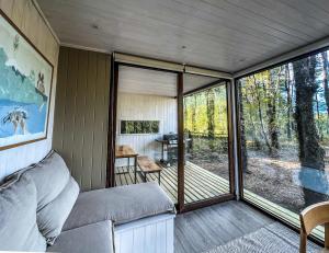 a screened in porch with a bed and a table at Carintia Cabins in Puerto Varas