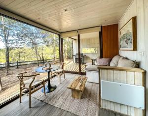a room with a bed and a table and chairs at Carintia Cabins in Puerto Varas