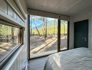a bedroom with a bed and a large window at Carintia Cabins in Puerto Varas