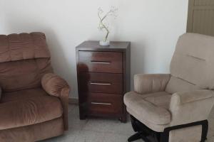 a living room with a chair and a chair and a dresser at La casa de Doña Emma in Lima del Alto