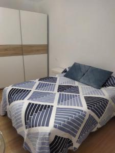 um quarto com uma cama com um edredão azul e branco em Habitación doble em Astigarraga