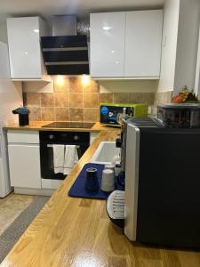 a kitchen with white cabinets and a counter top at Petite Maison Proche aéroport Charles de Gaulles in Drancy