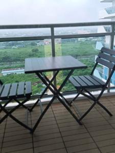 einen Picknicktisch und zwei Stühle auf dem Balkon in der Unterkunft BALI TOWER AZURE NORTH RESIDENCES in Lagundi