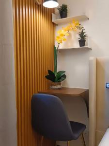 a desk with a blue chair and a plant at BALI TOWER AZURE NORTH RESIDENCES in Lagundi
