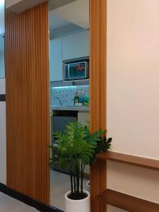 a kitchen with a microwave and a potted plant at BALI TOWER AZURE NORTH RESIDENCES in Lagundi