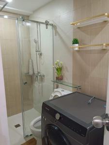 a bathroom with a shower and a washing machine at BALI TOWER AZURE NORTH RESIDENCES in Lagundi