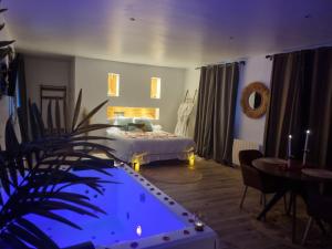 Habitación con cama y piscina. en "Levasion romantique" loft jacuzzi jardin privatif près de Paris en Saint-Prix