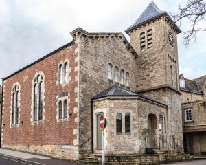 una antigua iglesia de ladrillo con una torre de reloj en Fresh and Luxurious Stylish, Grade II Listed Church conversion with Workspace, centrally located en Stow on the Wold