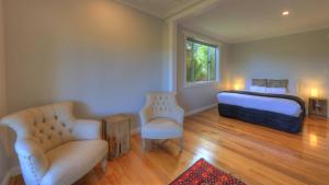 a bedroom with a bed and two chairs at Castaway Cottage in Dover
