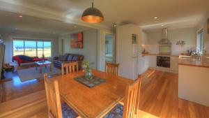a kitchen and living room with a wooden table at Castaway Cottage in Dover +10 photos