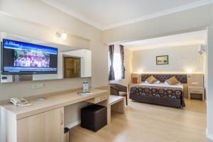 a hotel room with a bed and a large screen television at Asdem Park Otel in Kemer