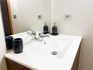 La salle de bains est pourvue d'un lavabo blanc et d'un miroir. dans l'établissement Vistas Al Valle De Arinsal 434 - Caminando a Pistas 1 MINUTO - 1Parking, à Arinsal