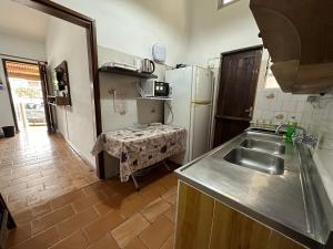 eine Küche mit einer Spüle und einem Kühlschrank in der Unterkunft Casa grande 3 dormitorios playa alvorada in Barra del Chuy
