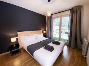 a bedroom with a large bed and a large window at Vistas Al Valle De Arinsal 434 - Caminando a Pistas 1 MINUTO - 1Parking in Arinsal