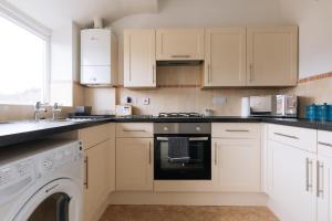 a kitchen with white cabinets and a dishwasher at Bright & Delightful 2BD Flat Clifton Down Bristol in Bristol