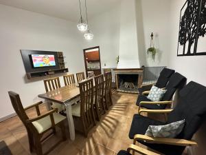 uma sala de estar com uma mesa e cadeiras e uma televisão em Casa grande 3 dormitorios playa alvorada em Barra del Chuy