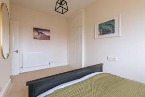 a bedroom with a bed and two pictures on the wall at Bright & Delightful 2BD Flat Clifton Down Bristol in Bristol