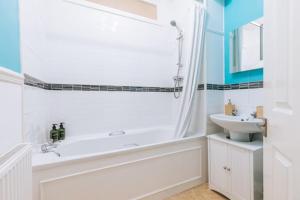a white bathroom with a tub and a sink at Bright & Delightful 2BD Flat Clifton Down Bristol in Bristol