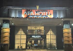 un hôtel avec un panneau en haut de celui-ci la nuit dans l'établissement APA Hotel TKP Sapporo Eki-Kitaguchi Excellent, à Sapporo