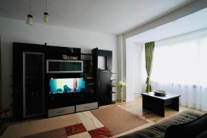 a living room with a tv and a couch at Central Park Apartments in Piatra Neamţ