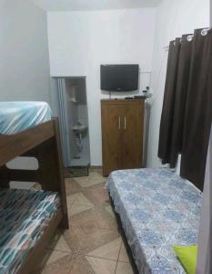 um quarto com uma televisão, uma cama e uma secretária em Casa no ABC perto de São Paulo Expo e Jd botanico em São Paulo