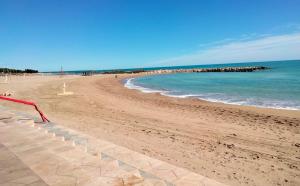 a sandy beach with the ocean and a red flag at MARiPEP Playa Vinaròs in Vinarós