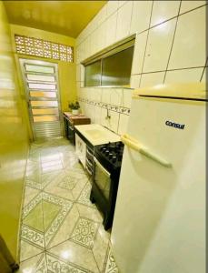 uma cozinha com um frigorífico branco e um fogão em Casa no ABC perto de São Paulo Expo e Jd botanico em São Paulo