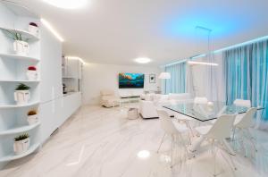 una sala de estar blanca con mesa de cristal y sillas en Emirates White Sensation en Sofía