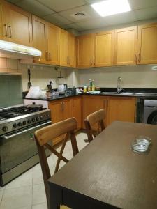 a kitchen with wooden cabinets and a table with chairs at Ruby Star Hostel Dubai F 4 R 2-3 in Dubai