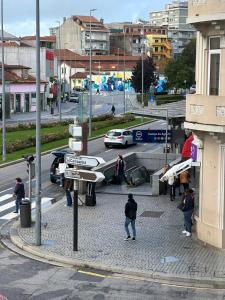 um grupo de pessoas andando em torno de uma rua com um carro em Easy Host Porto em Porto