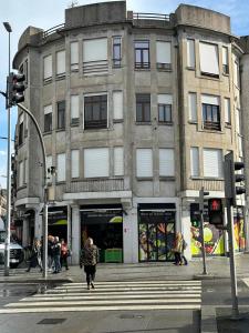 um prédio na esquina de uma rua com pessoas andando na frente em Easy Host Porto em Porto