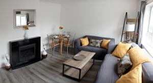 a living room with a couch and a fireplace at Mowbray Quarters of Cambridge in Cambridge