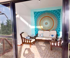 uma sala de estar com duas cadeiras e um quadro na parede em Casuarinas Del Mar Chalet de 2 habitaciones em Canoas de Punta Sal