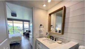 baño con lavabo, espejo y cama en Newly Renovated! Steps from Maui's Famous Beaches!, en Wailea