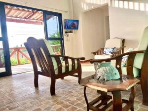 ein Zimmer mit Schaukelstühlen und ein Zimmer mit einem Fenster in der Unterkunft Casuarinas Del Mar Chalet de 2 habitaciones in Canoas De Punta Sal