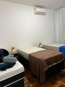 1 dormitorio con 2 camas y calefactor en la pared en Apartamento 2 quartos Copacabana, en Río de Janeiro