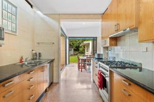 uma cozinha com armários de madeira e um forno com placa de fogão em KING44 - King Charming em Fremantle
