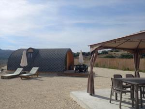 a building with a table and chairs and a tent at Glamping Pod in Prodhromi