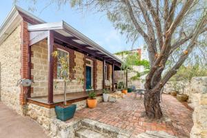 a brick house with a tree on a brick sidewalk at King Charming Cottage - Walk to the River in Fremantle