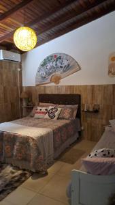 a bedroom with a bed and a chandelier at Paraíso do Ribeirao da Ilha in Florianópolis